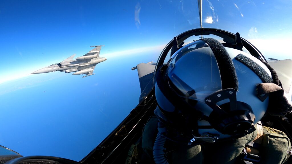 Stíhací letouny Gripen při cvičném letu nad mořem, pohled z kabiny pilota