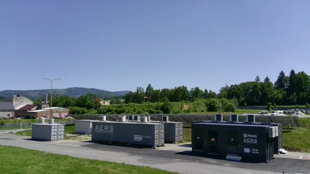 Průmyslové úložiště SAS v Energetickém centru FENIX Jeseník Průmyslové bateriové úložiště SAS v Energetickém centru FENIX Jeseník s kontejnery AERS a solárními panely.