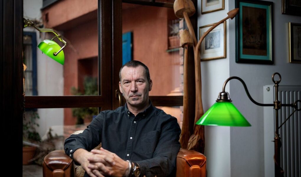 Profesor Jiří Horáček sedí v interiéru u okna.