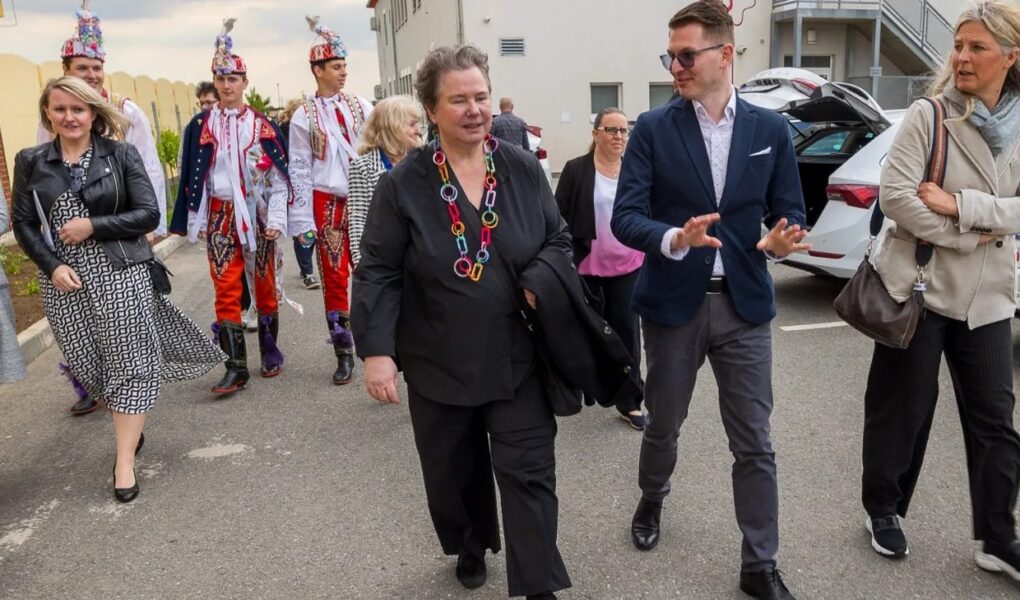 Princezna Maria Pia z Lichtenštejna přichází k budově Mateřské školy Hrušky, vspolu s doprovodem.