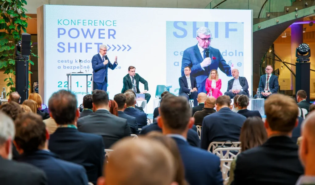 Ministr průmyslu a obchodu Karel Havlíček na pódiu během konference POWER SHIFT, za ním panelová diskuse a publikum v sále.
