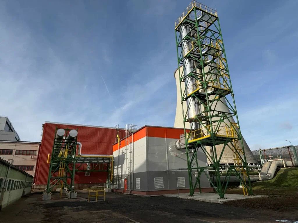 Venkovní pohled na plynovou kotelnu s technologickou věží a potrubními rozvody v areálu energetického provozu.
