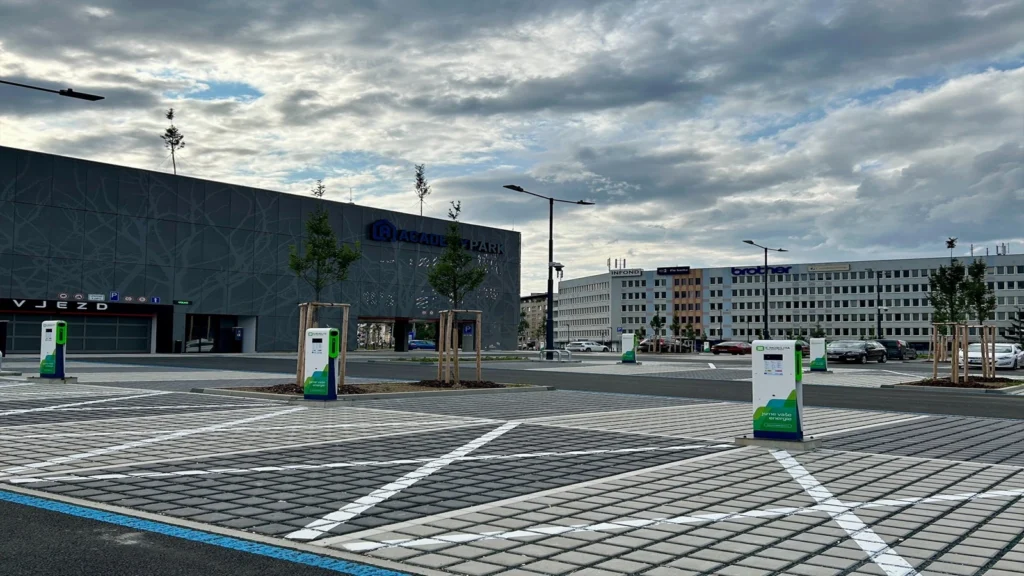 EV charging stations in a parking lot in front of the Academy Park building and nearby offices.