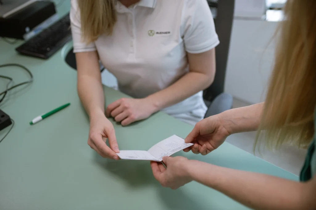 A patient hands a vaccination card to a staff member at an Avenier vaccination centre.